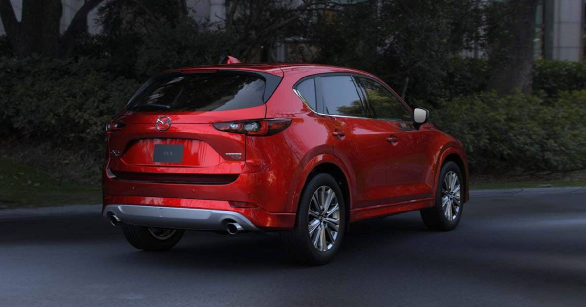 Rear view of a red Mazda CX-5 parked on the street, showing dual exhausts and slim taillights.